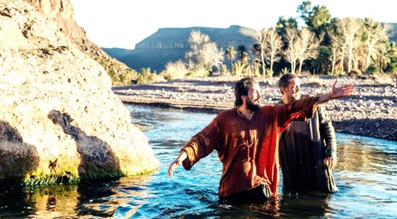 Una pintura artística que representa al bautismo por inmersión de Saulo de Tarso por Ananías en un río cerca de Damasco.